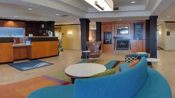 Eine moderne Lobby mit Empfangsschalter, Sitzgelegenheit und Kamin.