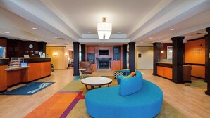 A spacious lobby with a reception desk, seating area, and a fireplace. - Fairfield Inn & Suites by Marriott Clermont (Clermont)