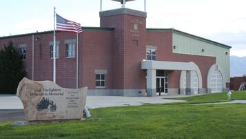 A building with a flag, a sign, and a grassy area.