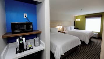 A hotel room with a microwave, a coffee maker, and a minibar.