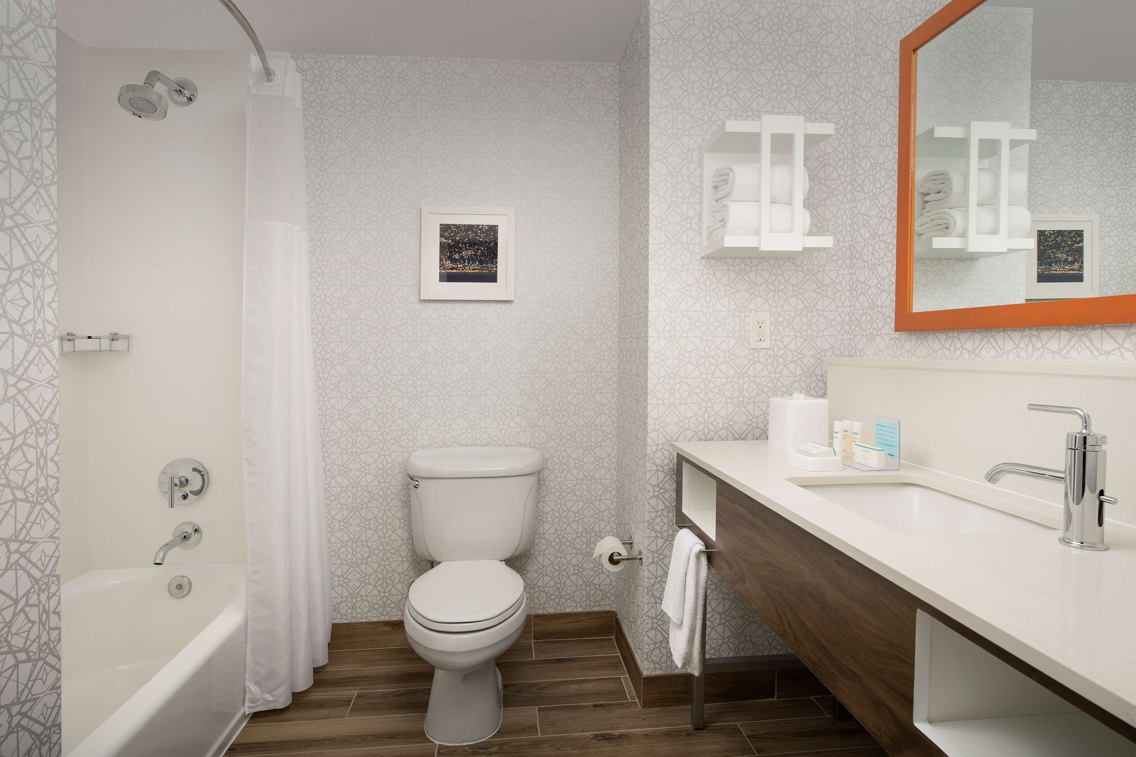 A modern bathroom with a bathtub, toilet, and sink.