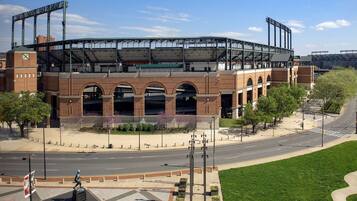 A stadium with a large open field, multiple arches, and a covered seating area.