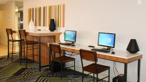 A modern office space with two desks, each with a computer and chair.