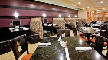 A restaurant with booths, tables, and a tiled floor.