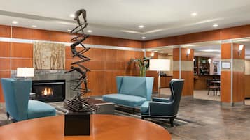 A lobby with a fireplace, seating area, and a reception desk.