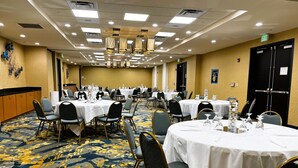 A conference room with multiple tables, chairs, and a carpeted floor. - Holiday Inn Hotel & Suites Williamsburg-Historic Gateway by IHG (Williamsburg)