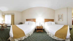 A hotel room with two beds, a desk, a chair, and a nightstand with a lamp. - Holiday Inn Express Hotel & Suites Sylacauga by IHG (Sylacauga)