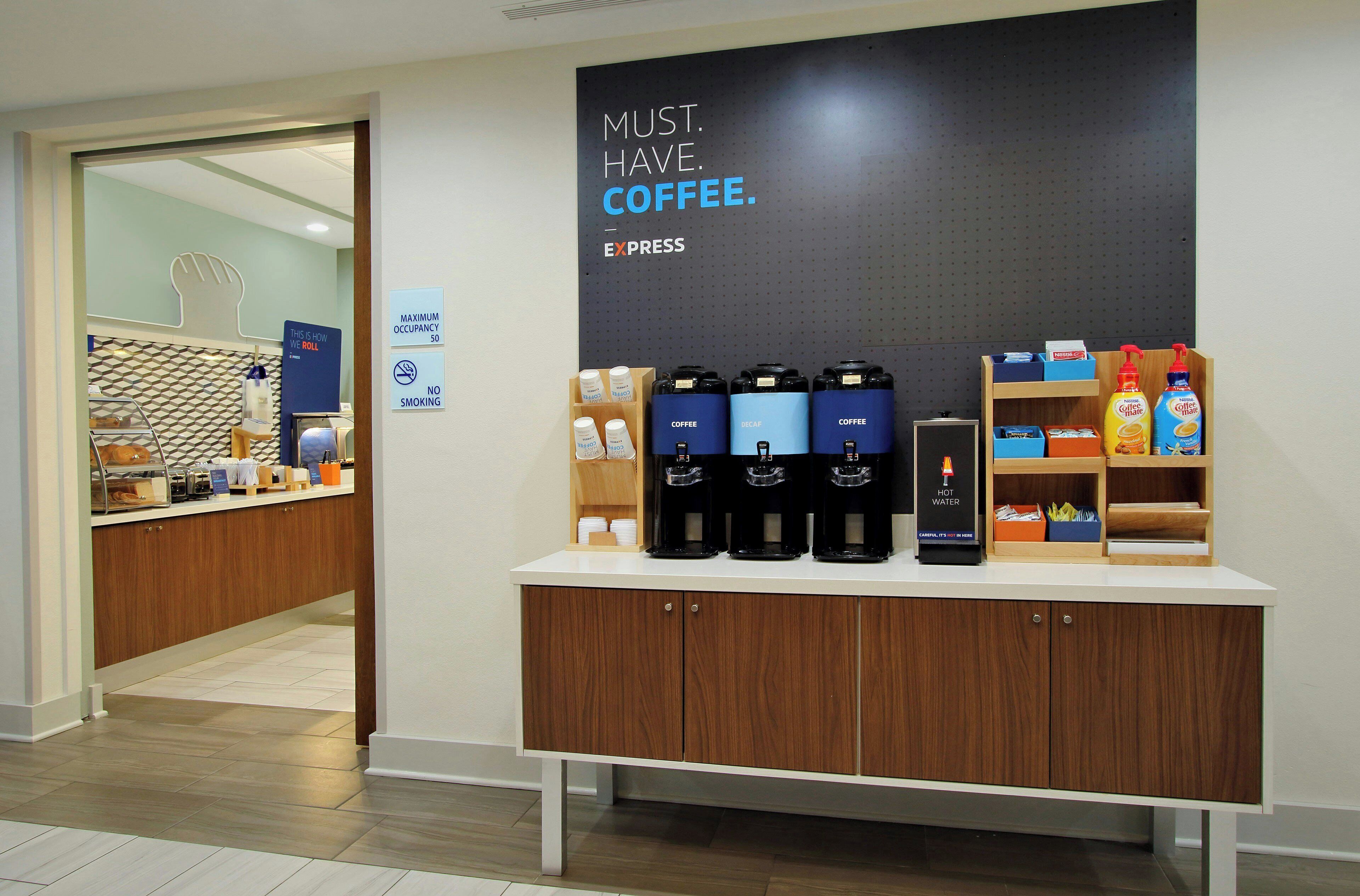 Una zona de cafè amb dispensadors, un cartell que diu 'MUST HAVE COFFEE' i un cartell de 'NO SMOKING'.