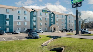 A multi-story hotel with a sign indicating extended stay options and a price per night.