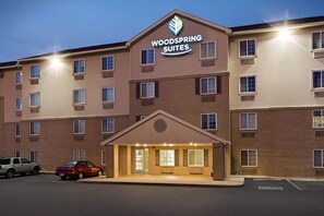 A multi-story hotel with a prominent sign reading "Woodspring Suites."