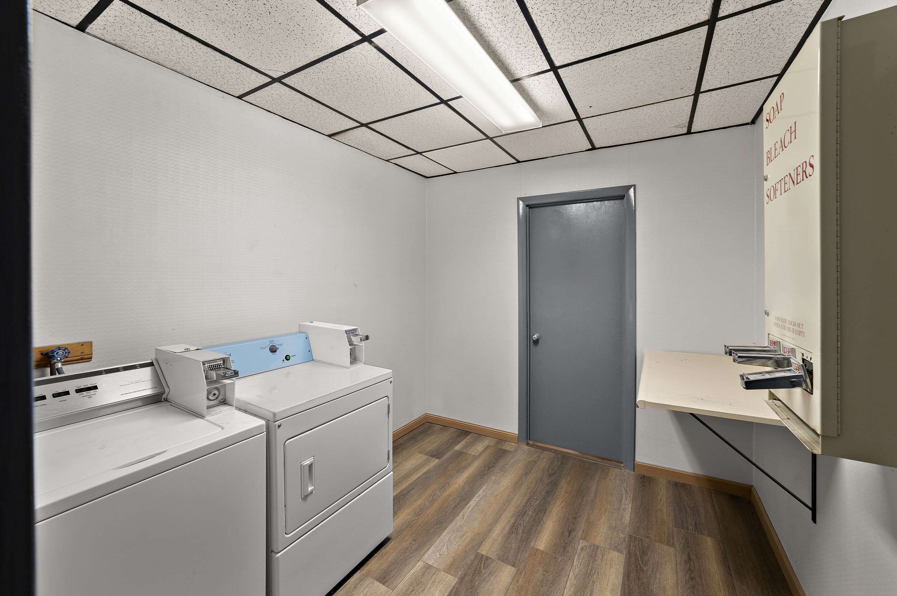 A laundry room with a washing machine, dryer, and a shelf with cleaning supplies.