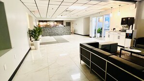 A spacious lobby with a reception desk, seating area, and a coffee machine. - Quality Inn & Suites Caribou (Caribou)