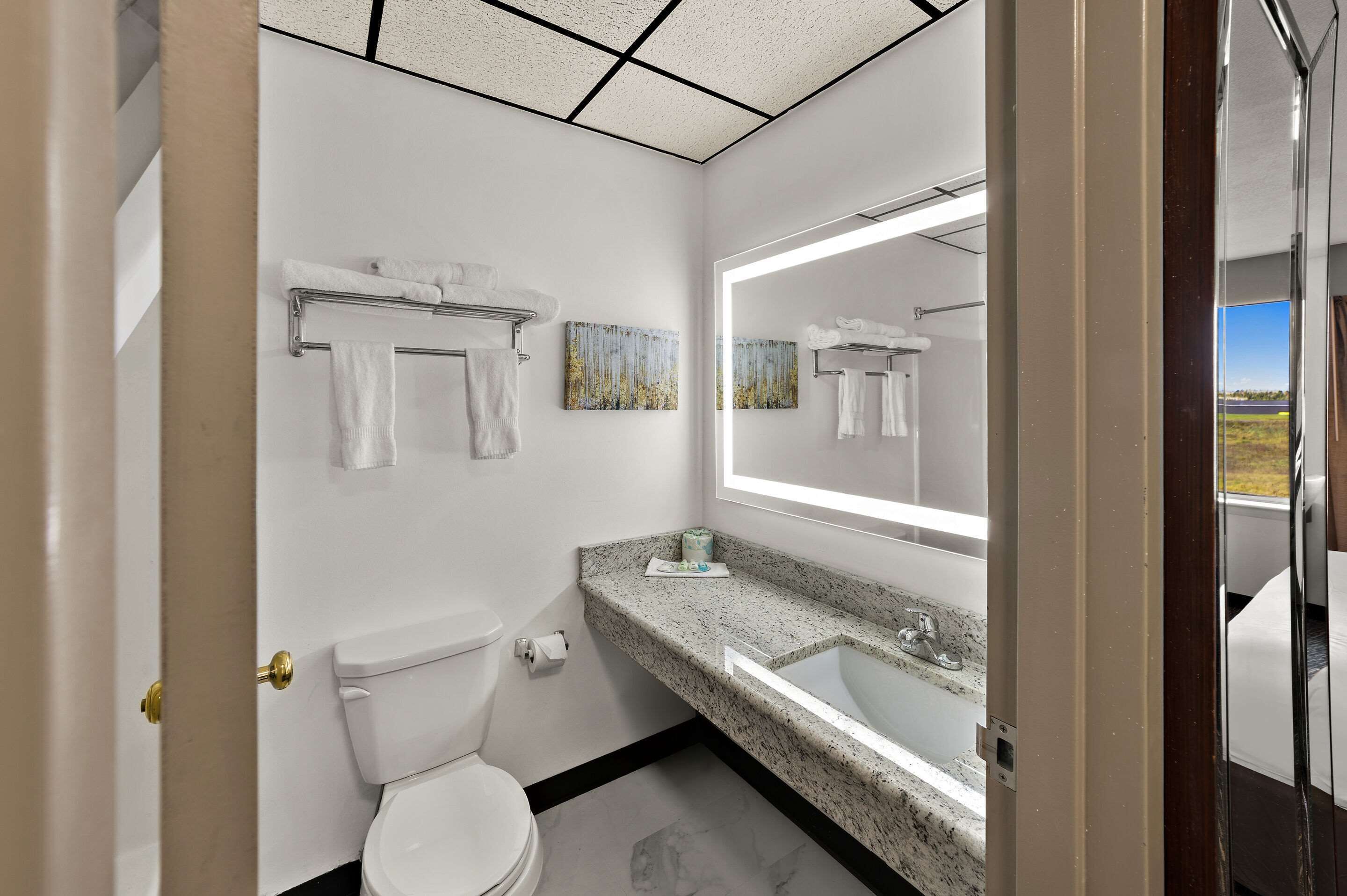 A modern bathroom with a toilet, sink, and towel rack.