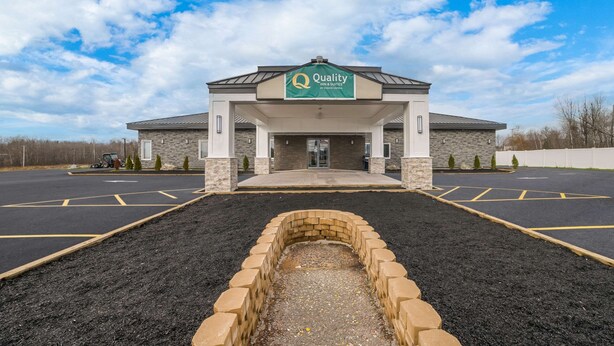 A hotel entrance with a sign reading "Quality Inn & Suites by CHOICE Hotels."