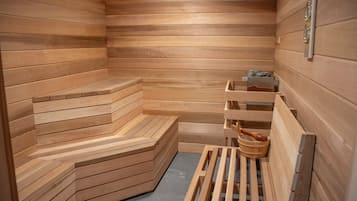 Una sauna de madera con asientos escalonados y un banco de madera.
