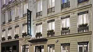 A hotel facade with multiple windows labeled "KEPPLER," featuring a classic architectural style with decorative moldings and potted plants on the windowsills. - Hôtel Keppler (Paris)