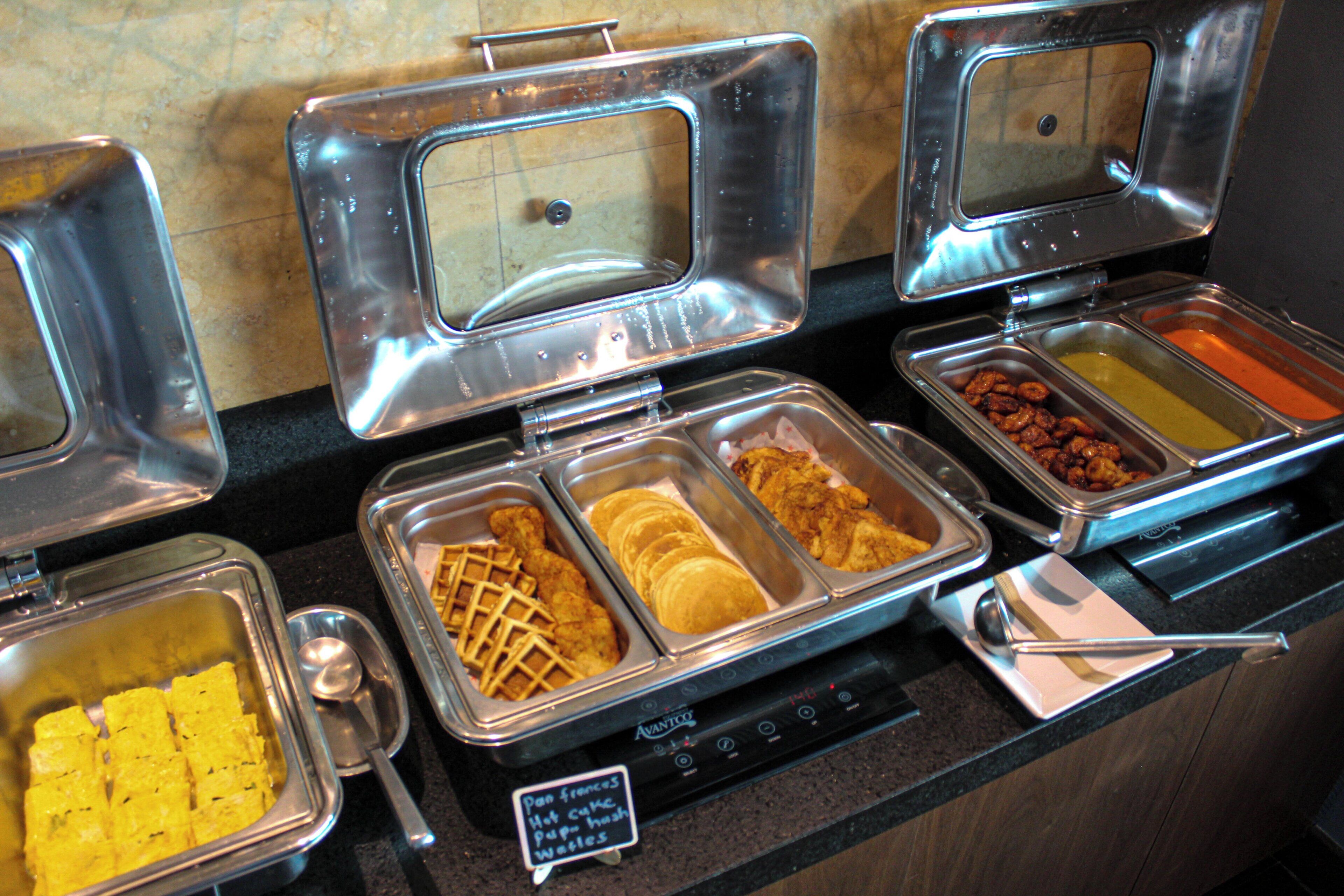 A buffet with various food items in metal containers.