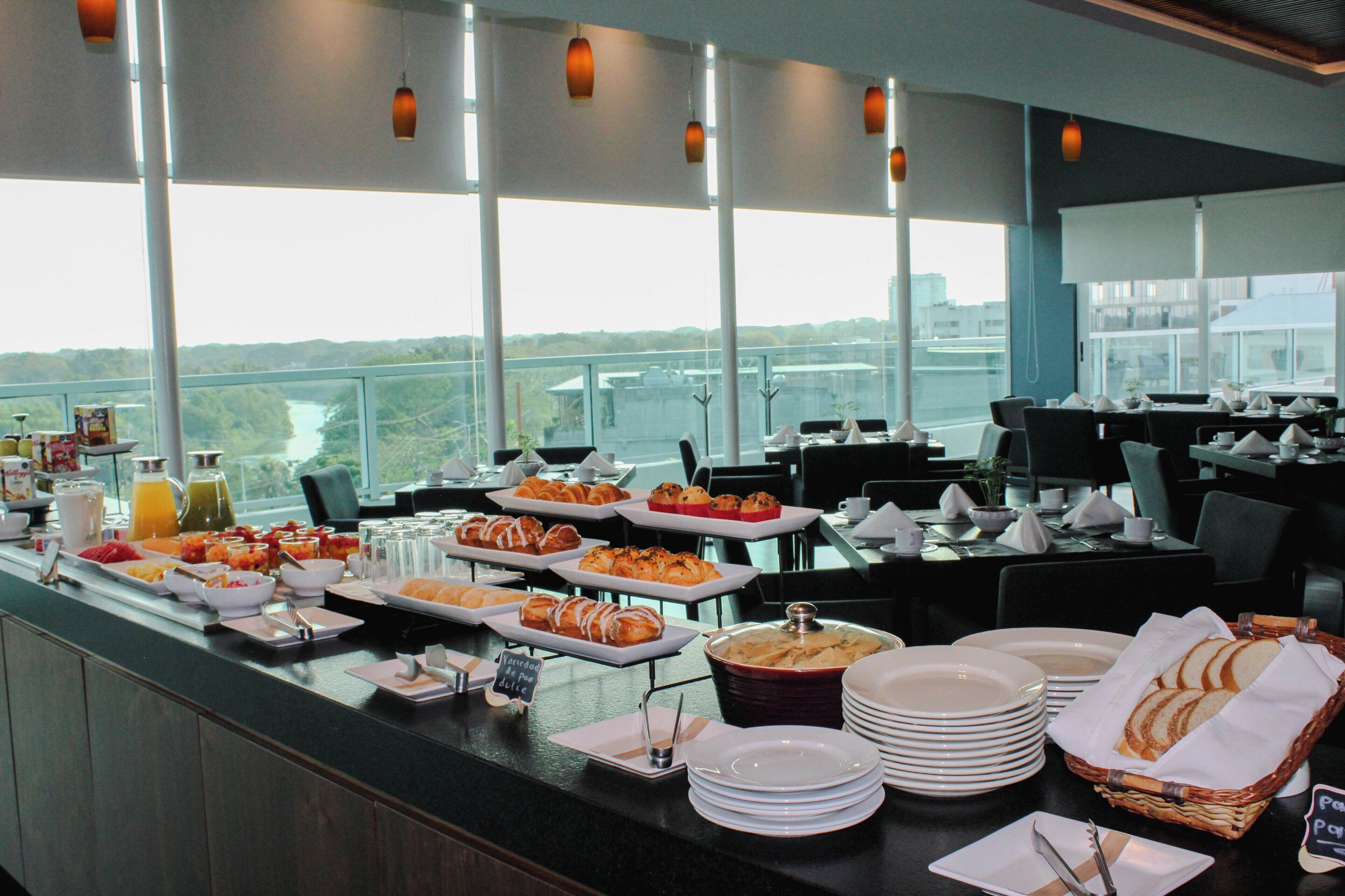 Buffet amb diferents plats per esmorzar i vista a la ciutat.
