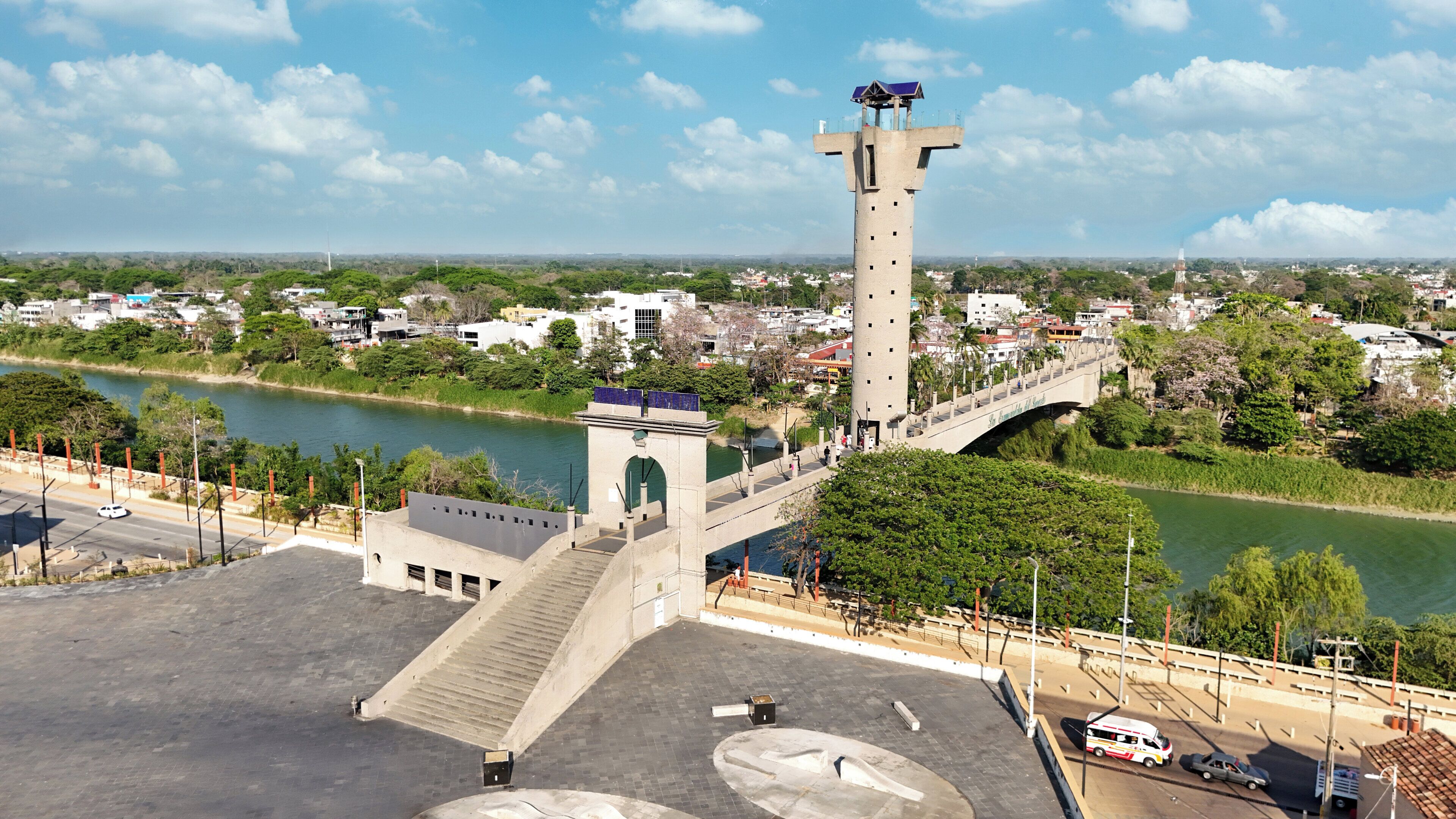 A large building with a prominent tower, a bridge, and a river.
