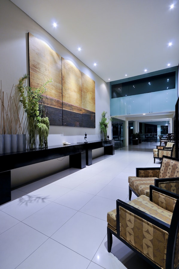 A spacious lobby with a reception desk, seating area, and a large abstract painting on the wall. - Crowne Plaza Villahermosa by IHG (Villahermosa)
