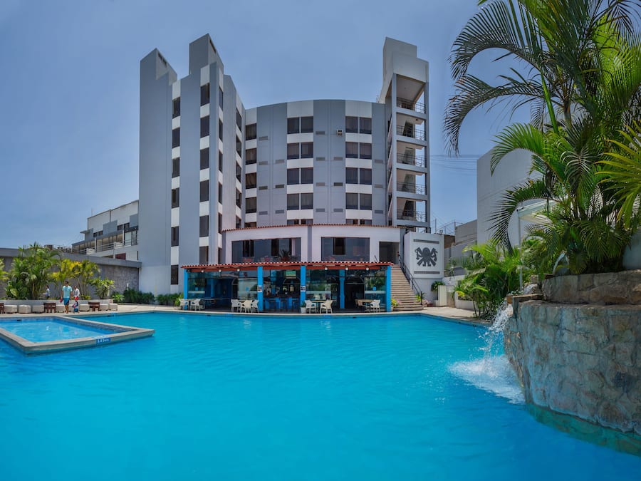 Una piscina al aire libre, sillones reclinables de piscina