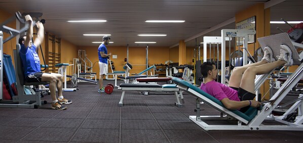 A gym with various exercise equipment, including weight machines and benches.