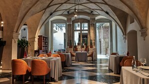 A restaurant with a high arched ceiling, marble flooring, and multiple tables set for dining. - Hotel Stary (Kraków)