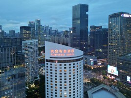 A high-rise hotel with a distinctive curved top and a large illuminated sign.