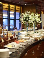 A buffet setup with various dishes and a floral centerpiece.