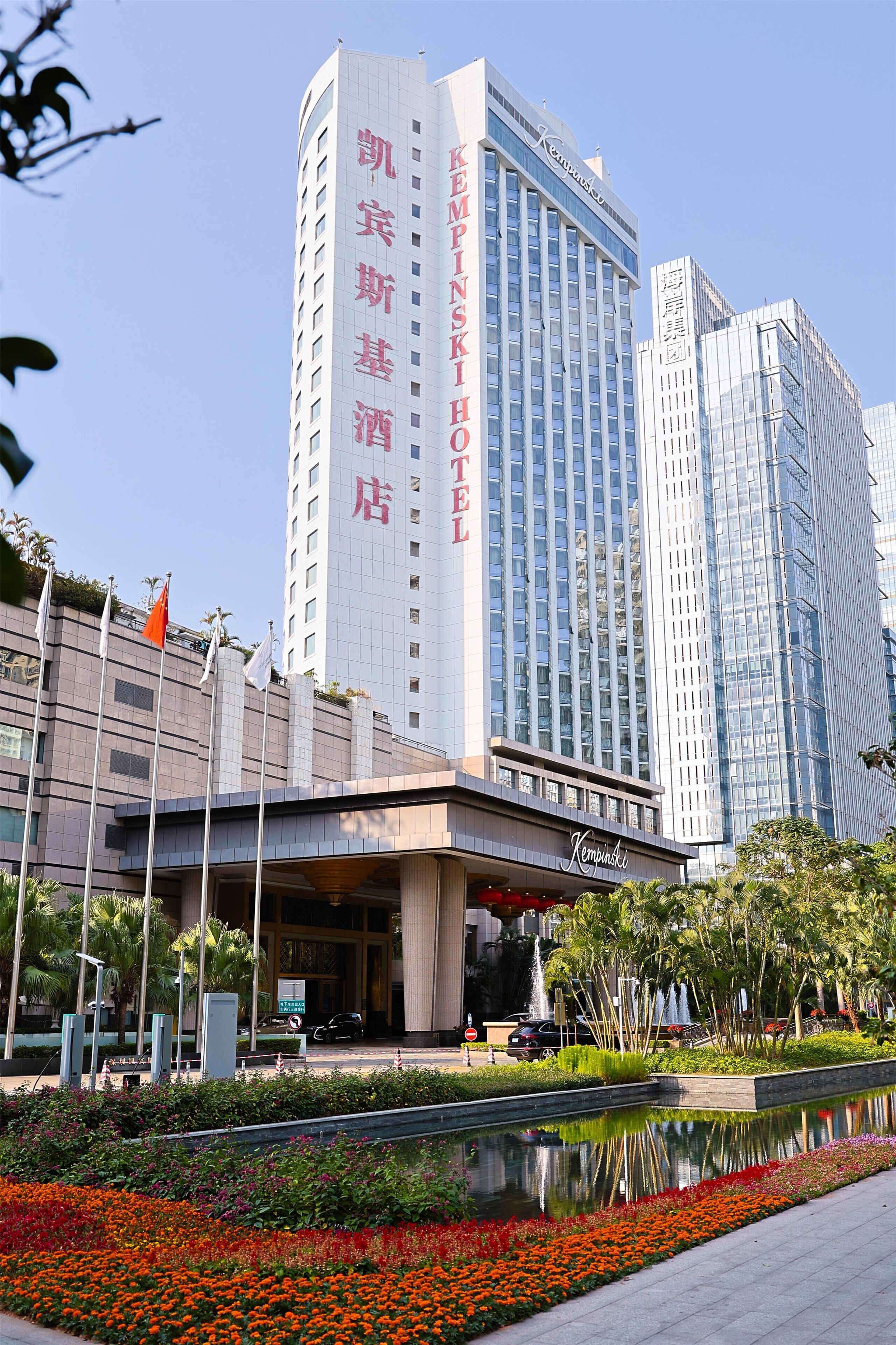 A hotel with a modern facade, a prominent entrance, and a reflection pool in the foreground.