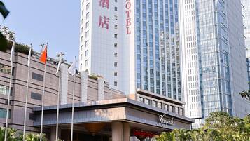 A hotel with a modern facade, a prominent entrance, and a reflection pool in the foreground.