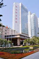 A hotel with a modern facade, a prominent entrance, and a reflection pool in the foreground.