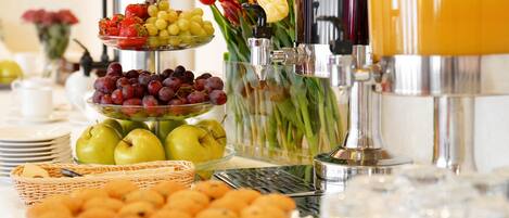 Una mesa de buffet con diversos alimentos, como frutas, verduras y pasteles.