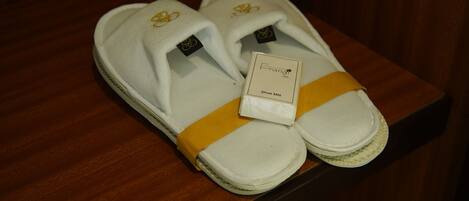 Un par de zapatillas blancas con detalles amarillos y una etiqueta que dice 'Frang Oslo Shoe Mitt'.