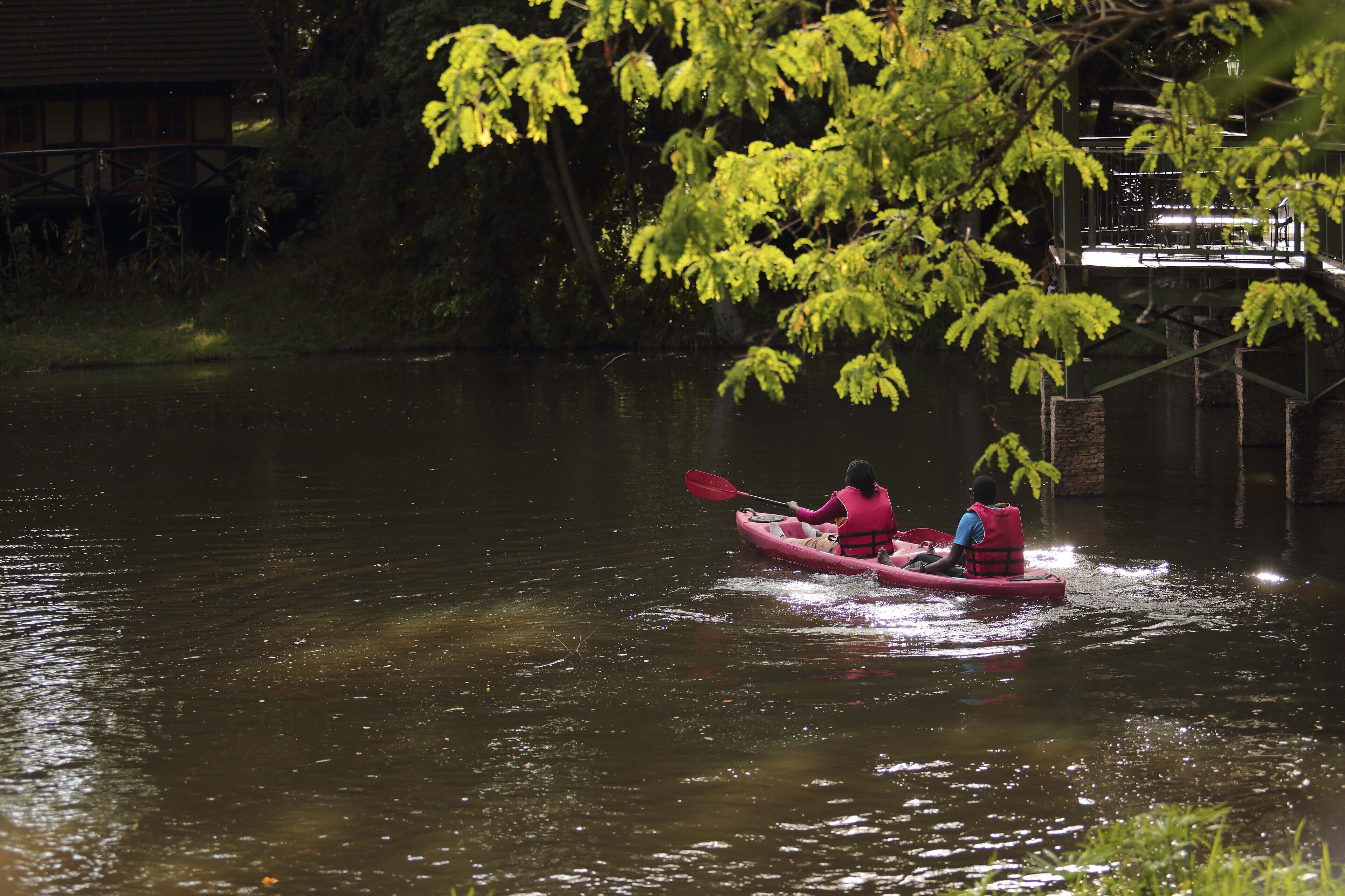 Une personne pratiquant le kayak sur une rivière la nuit.