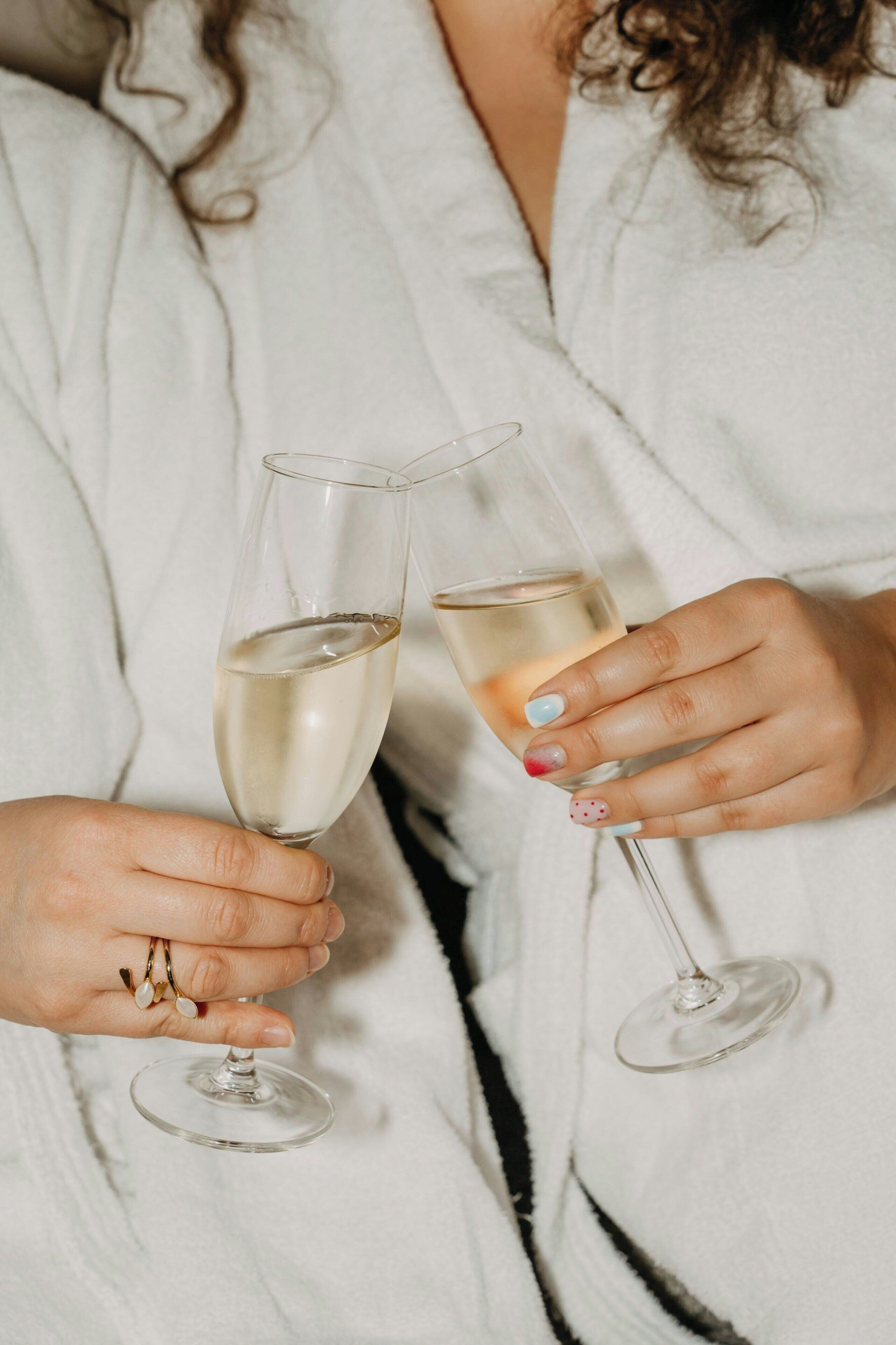 A person holding two wine glasses.