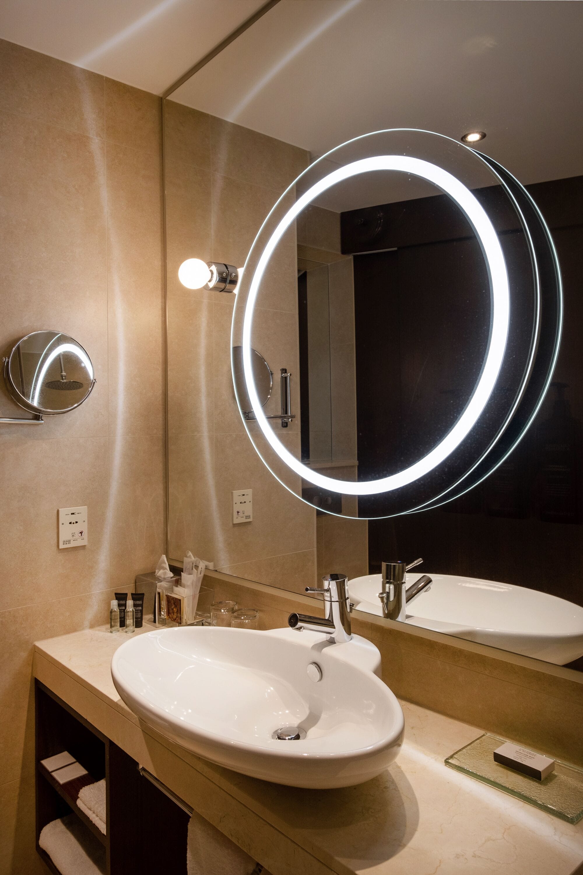 Ein modernes Badezimmer mit einem großen Spiegel, zwei Waschbecken und einem Waschtisch.