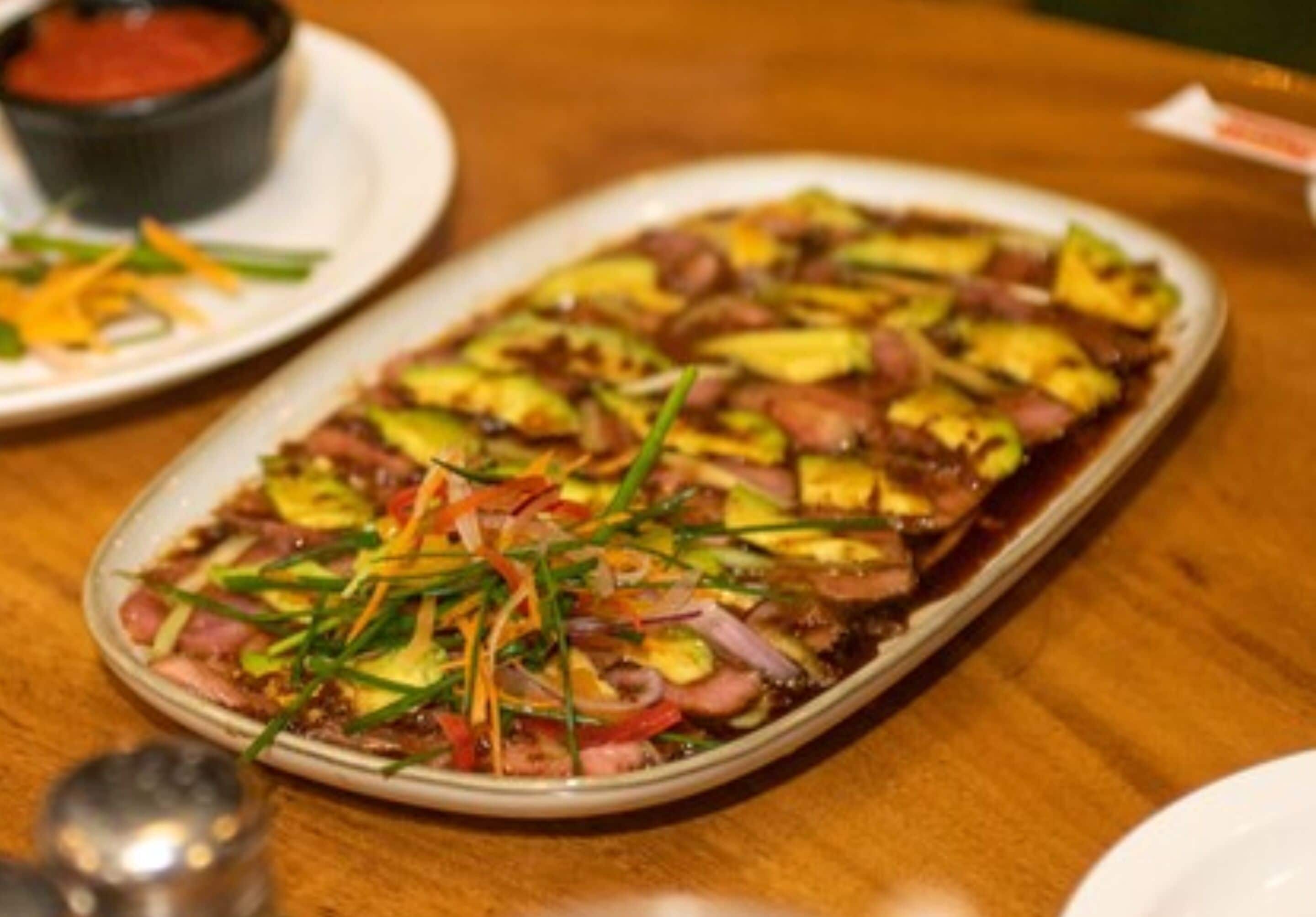 A dish with various vegetables and meat on a plate.