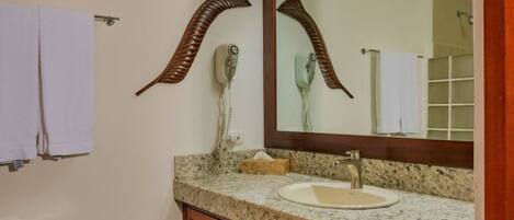 A bathroom with a toilet, sink, and mirror.