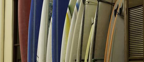 Une rangée de planches de surf appuyées contre un mur.