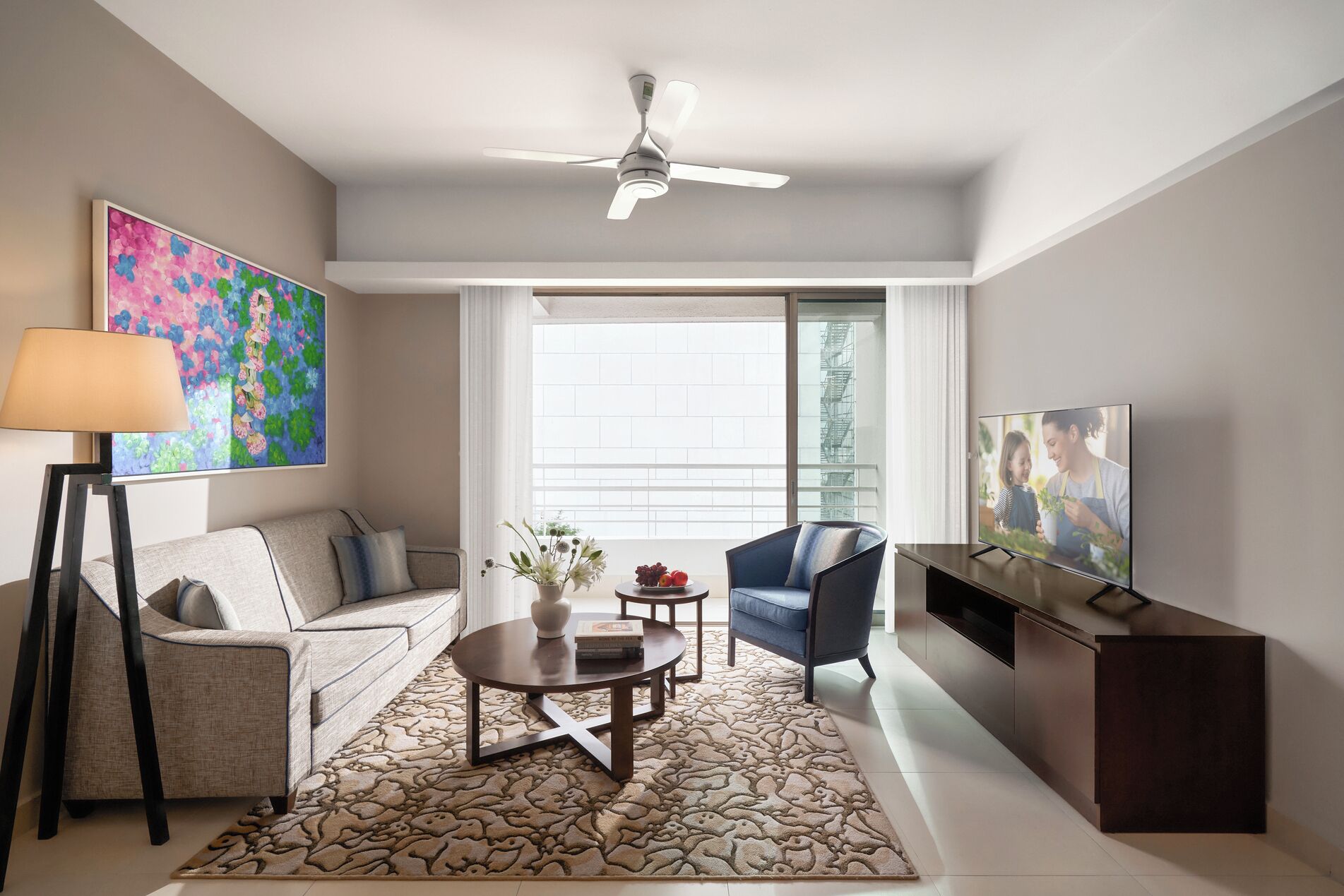A modern living room with a sofa, armchair, coffee table, and TV.