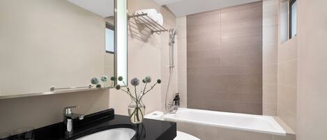 Ein modernes Badezimmer mit einem schwarzen Waschbecken, einer weißen Toilette und einer Badewanne.