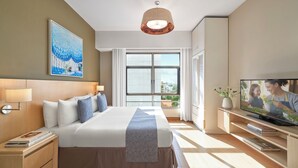 A modern hotel room with a large bed, a television, and a window with a city view. - Somerset Ho Chi Minh City (Ho Chi Minh City)