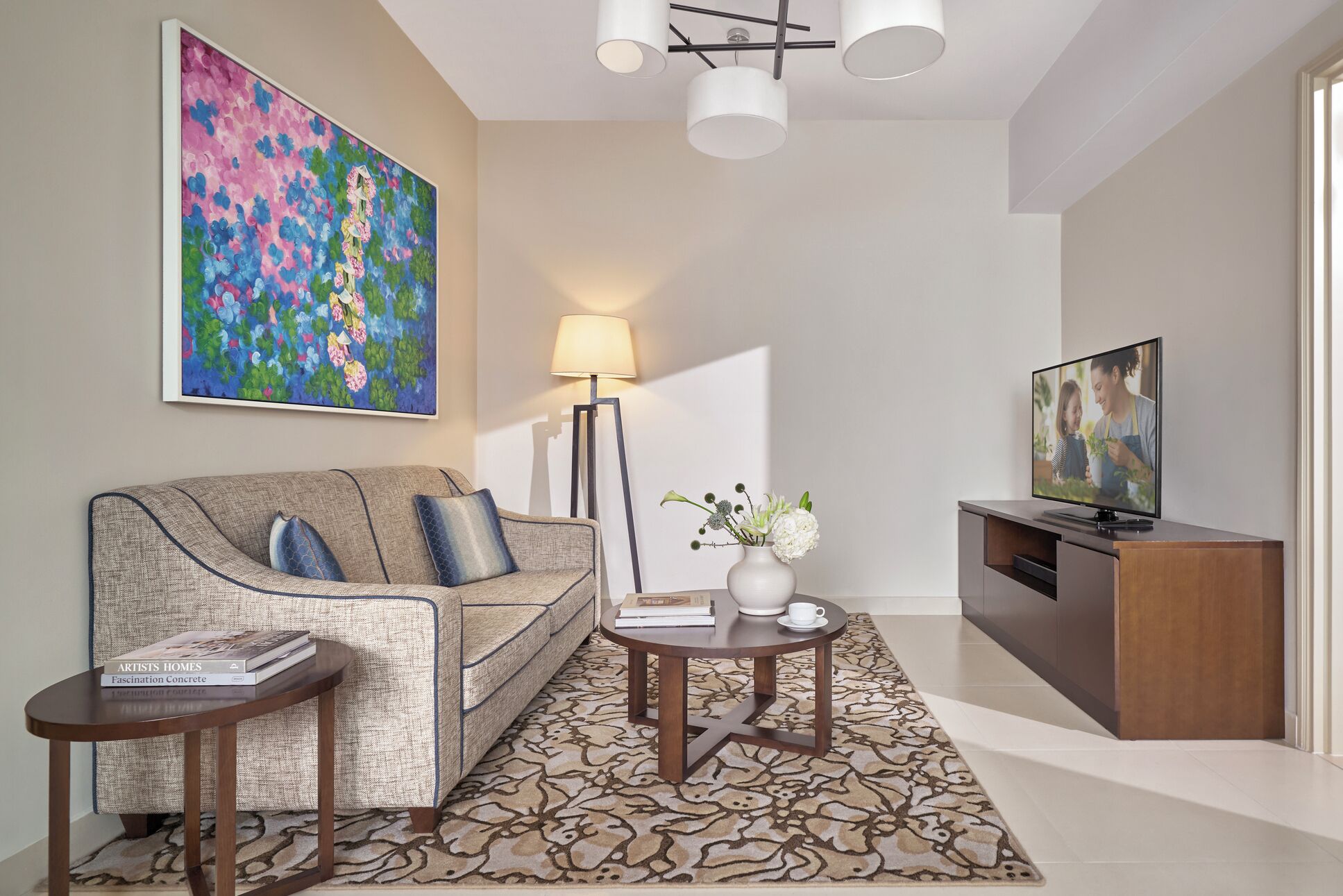 A modern living room with a sofa, coffee table, and TV stand.