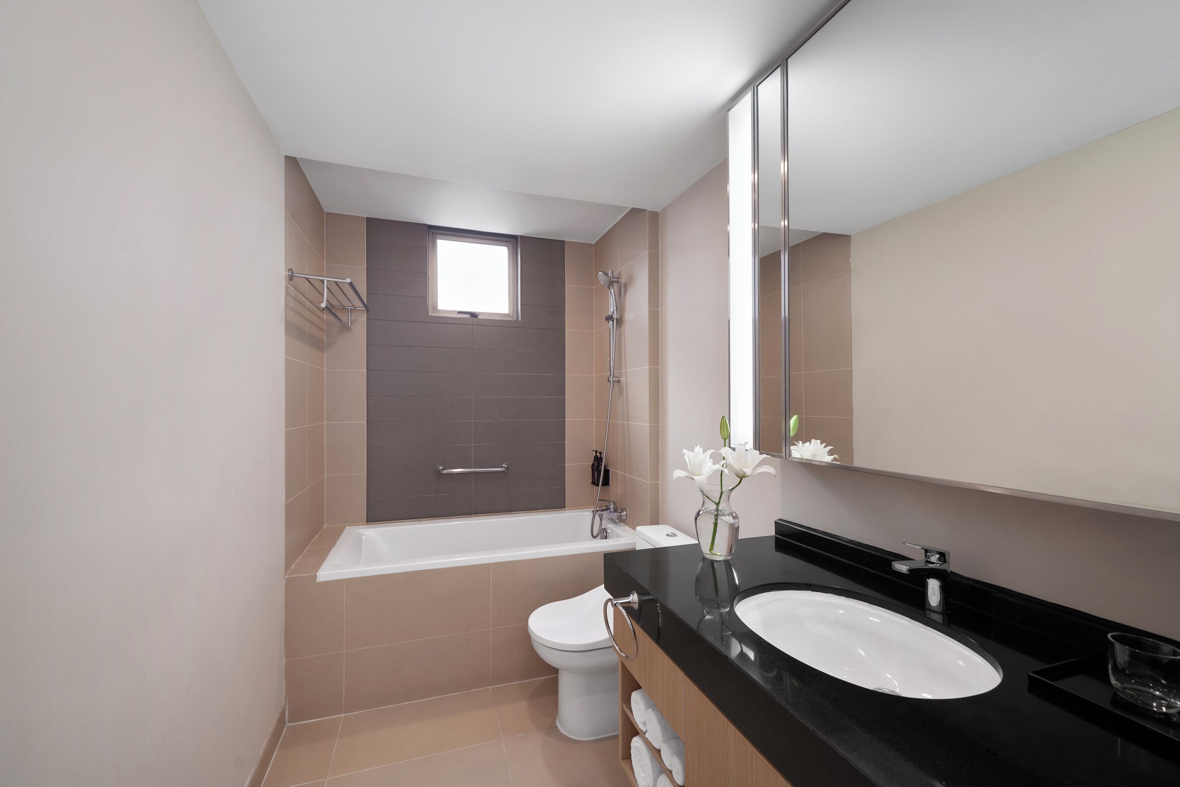 A modern bathroom with a bathtub, toilet, and sink.