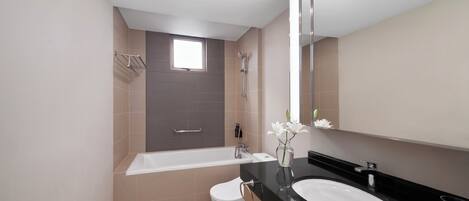 A modern bathroom with a bathtub, toilet, and sink.