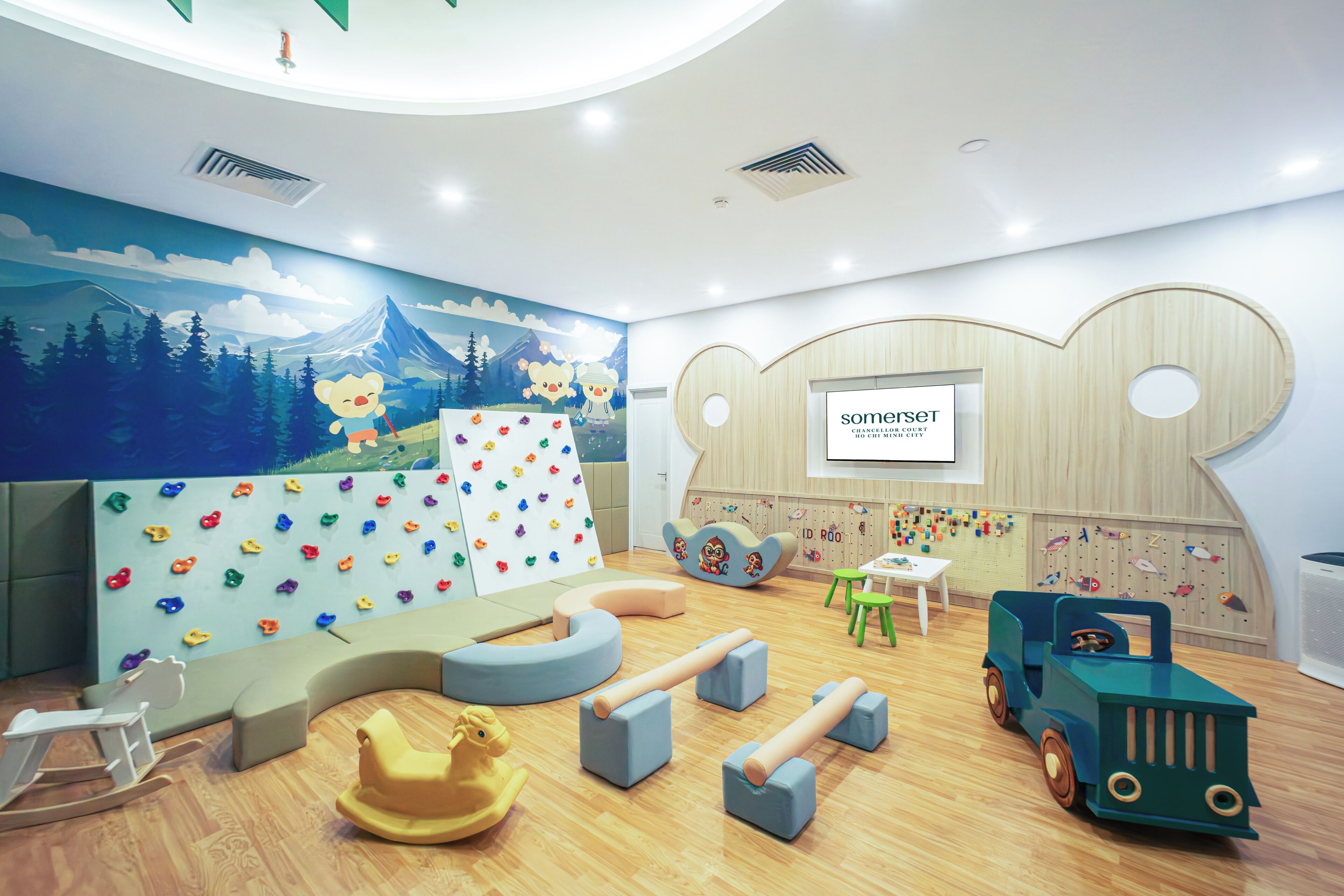 Ein Kinderspielzimmer mit Kletterwänden, einem Schaukelpferd und einem Spielzeug-LKW.