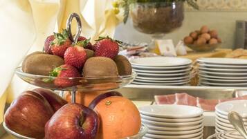 A buffet table with a variety of fruits and pastries.
