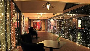Un restaurante con paredes de ladrillo, luces colgantes y una fuente de agua.