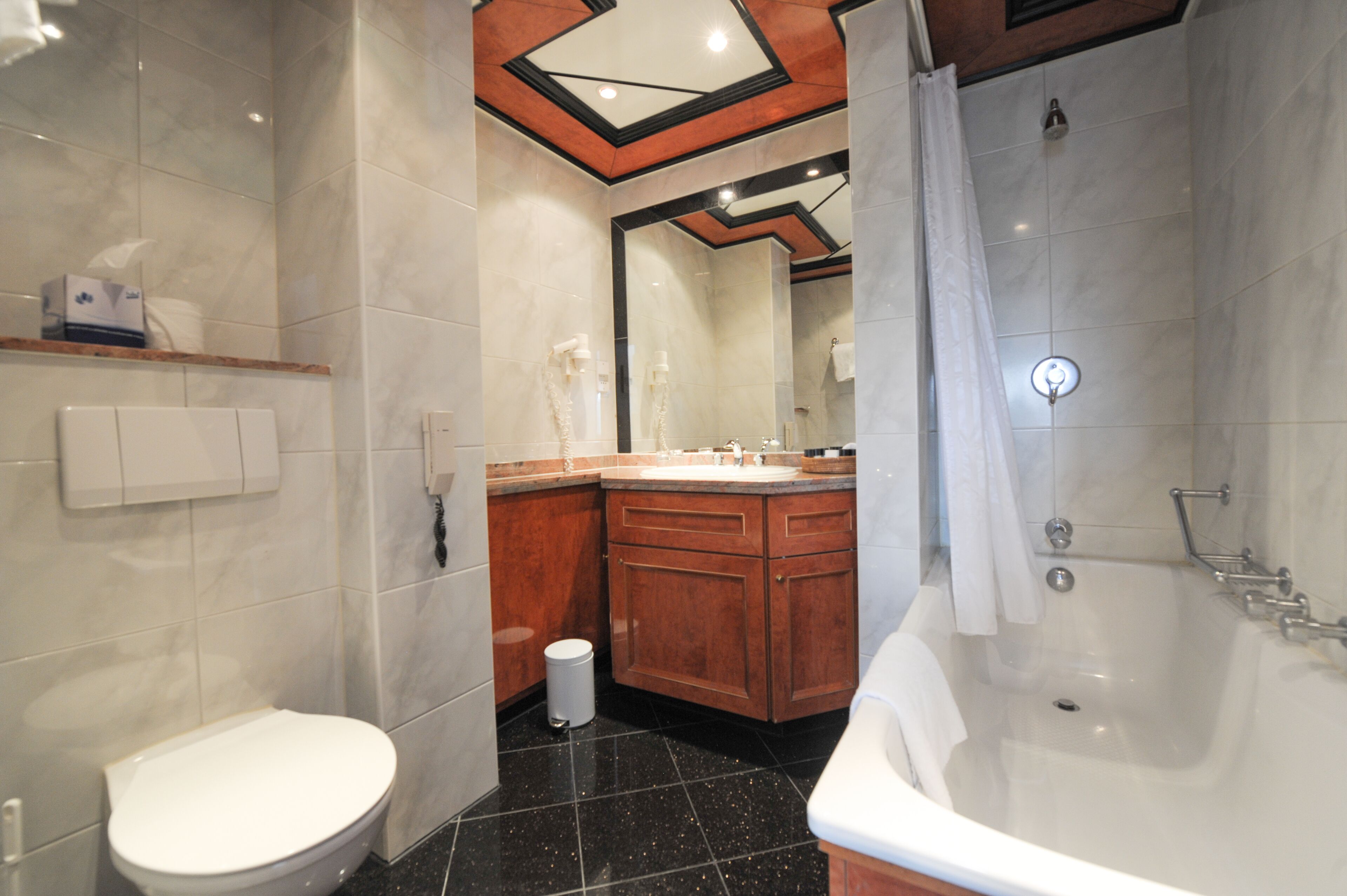 Un baño moderno con inodoro, lavamanos, tocador y bañera.